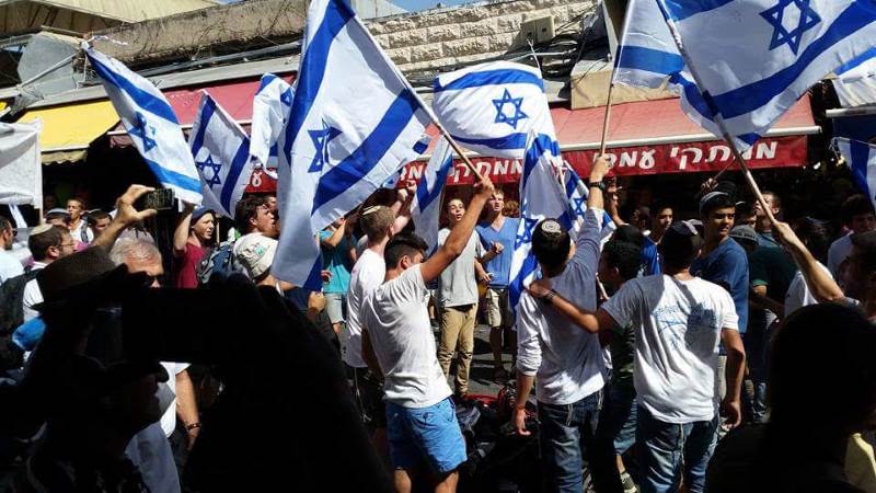מחזקים את ידי כוחות הביטחון. צעירים מניפים דגלים|צילום: המועצה הציונית בישראל חולקו סרטי כחול ולבן להרמת המורל בעם